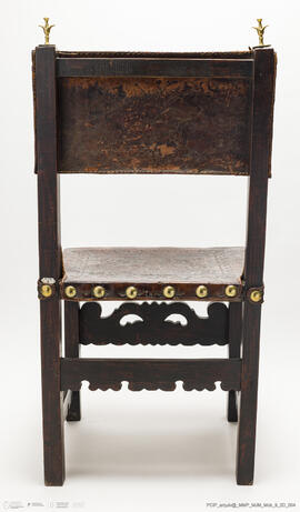 Cadeira de costas baixas em couro lavrado e com pregaria amarela