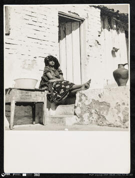 Mulher sentada ao sol no pátio do Casal das Figueiras