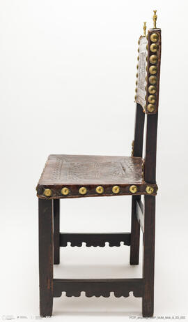 Cadeira de costas baixas em couro lavrado e com pregaria amarela