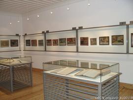 Sala com livros expostos e telas