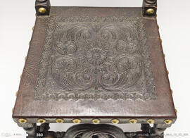 Cadeira de espaldar em couro lavrado com pregaria em metal dourado