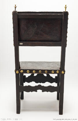 Cadeira de costas baixas em couro lavrado e com pregaria amarela