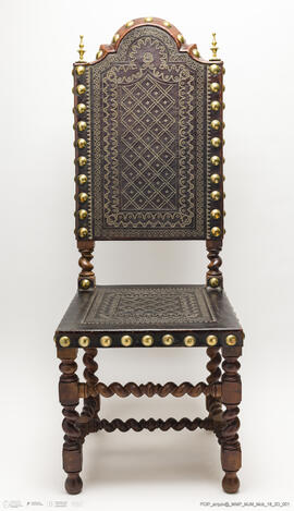 Cadeira de espaldar em couro lavrado com pregaria em metal dourado