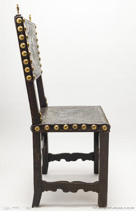 Cadeira de costas baixas em couro lavrado e com pregaria amarela