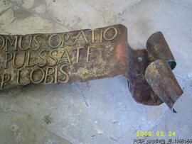 Detalhe da inscrição em bronze que está sob a porta