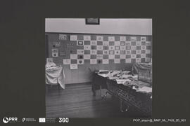 Mesa com documentos. Colagens na parede