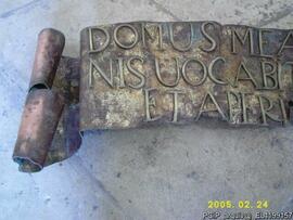 Detalhe da inscrição em bronze que está sob a porta