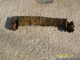 Detalhe da inscrição em bronze que está sob a porta