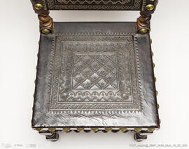 Cadeira de espaldar em couro lavrado com pregaria em metal dourado