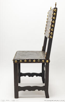 Cadeira de costas baixas em couro lavrado e com pregaria amarela